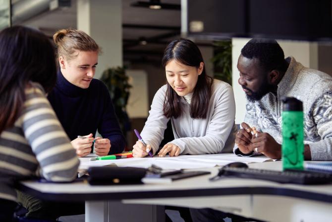 A group of students sitting around a table discussing pre-lecture materials